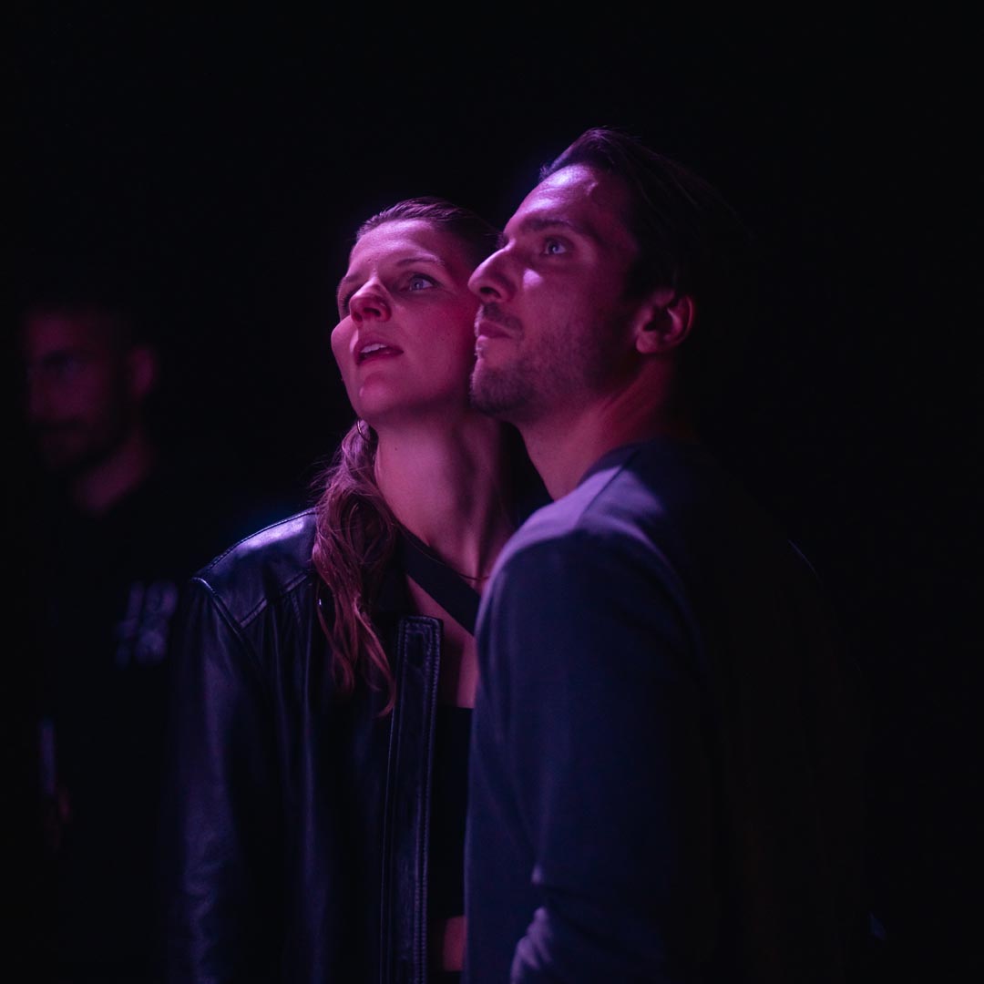 Two faces in the violet light.